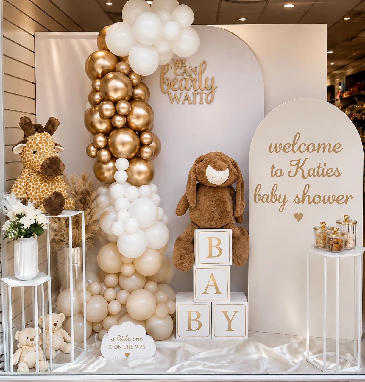 Teddy bear baby shower balloon display with gold chrome and cream organic garland, arch backdrop, BABY letter blocks and soft toy props — styled by Little Moment Studio, Sittingbourne